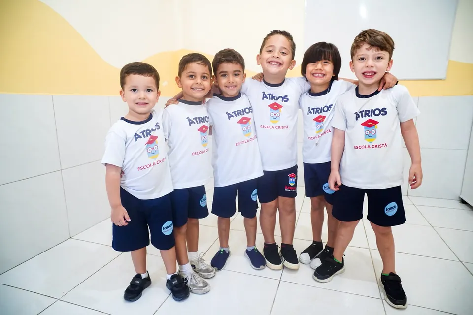 Seis amigos abraçados com o uniforme da Átrios