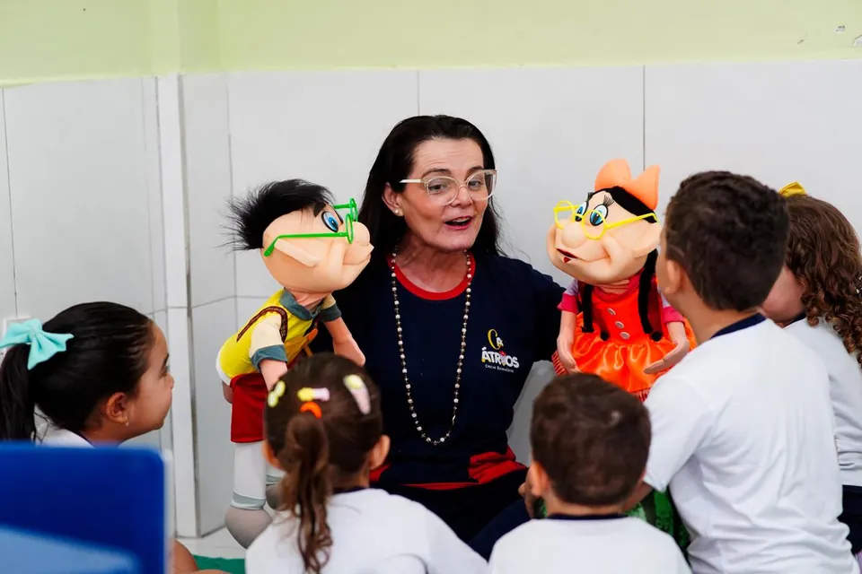 Professora contando história com fantoches para as crianças